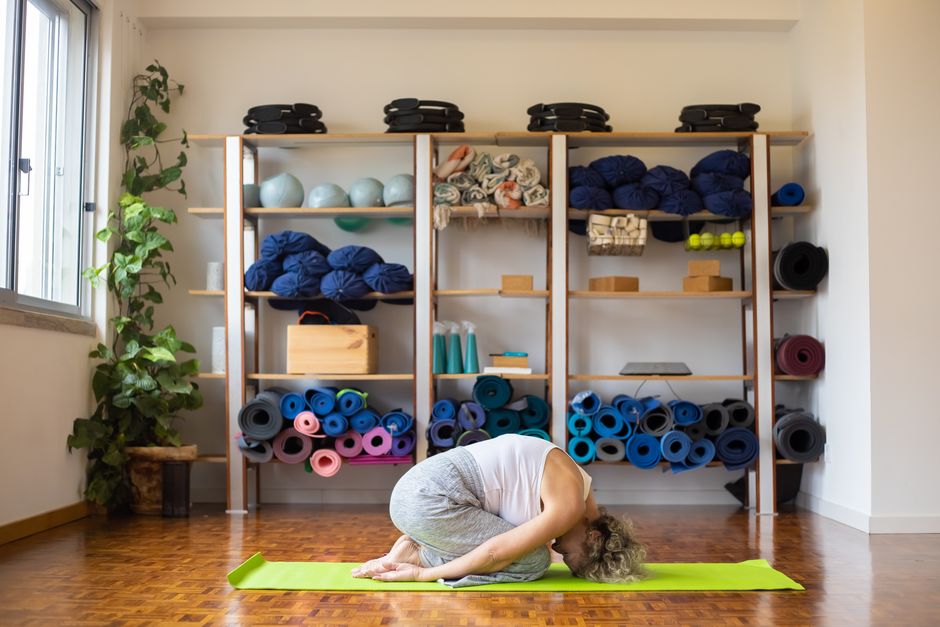 A student resting in a supported yin yoga pose with a bolster
